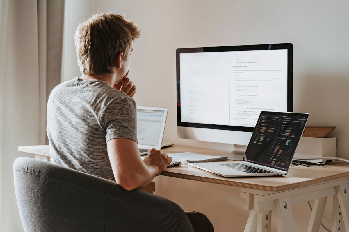 An engineer at a desk with three screens